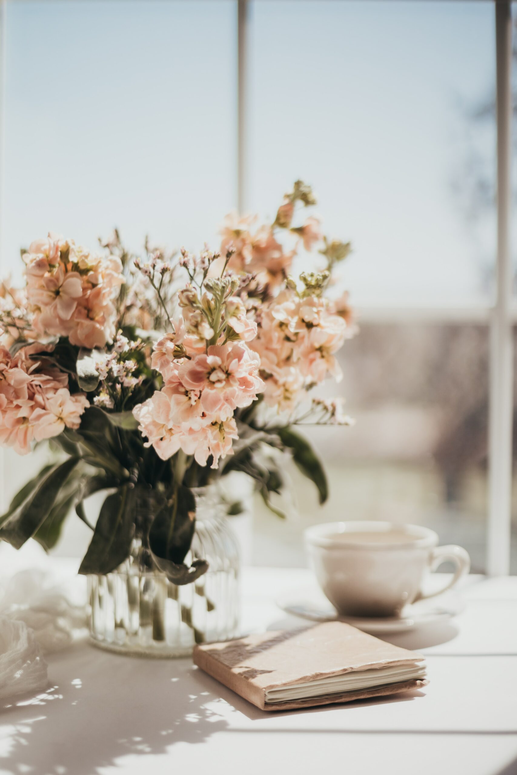 Flowers in a Vase Next to a Journal